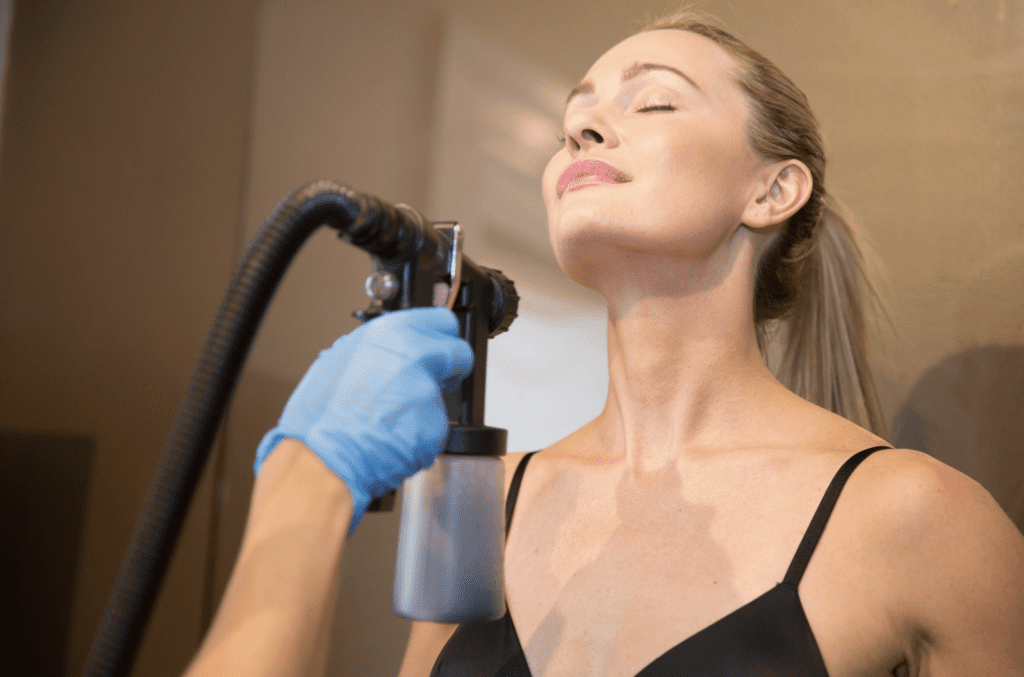 Up close of woman getting Pure Glow spray tan